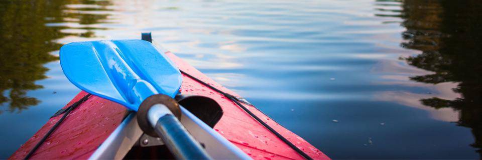 A canoe and paddle close up on a river