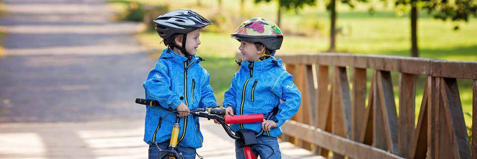 Two little brothers laughing on bikes 