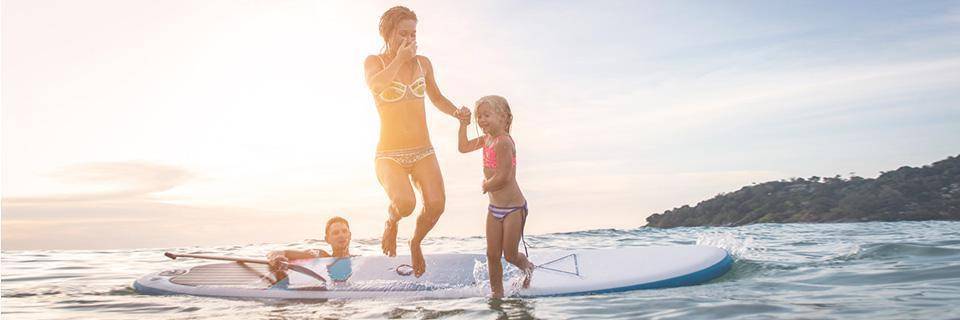 A family jumping off a SUP into the sea