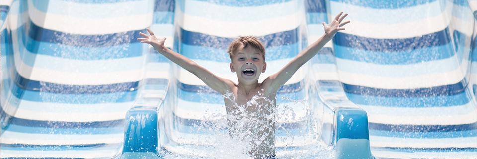 A boy slides down a slide at Aqualand