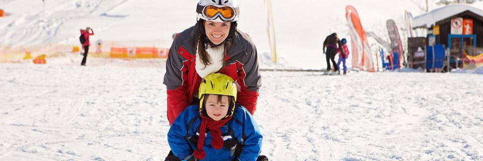 mum and little boy in the beginner section of the ski resort